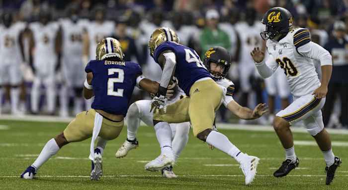 Sep 25, 2021; Seattle, Washington, USA; California Golden Bears place holder Jamieson Sheahan (37) is tackled by Washington Huskies defensive back Kyler Gordon (2) and linebacker Edefuan Ulofoshio (48) during field goal attempt in the first half of a game at Alaska Airlines Field at Husky Stadium. Mandatory Credit: Stephen Brashear-USA TODAY Sports